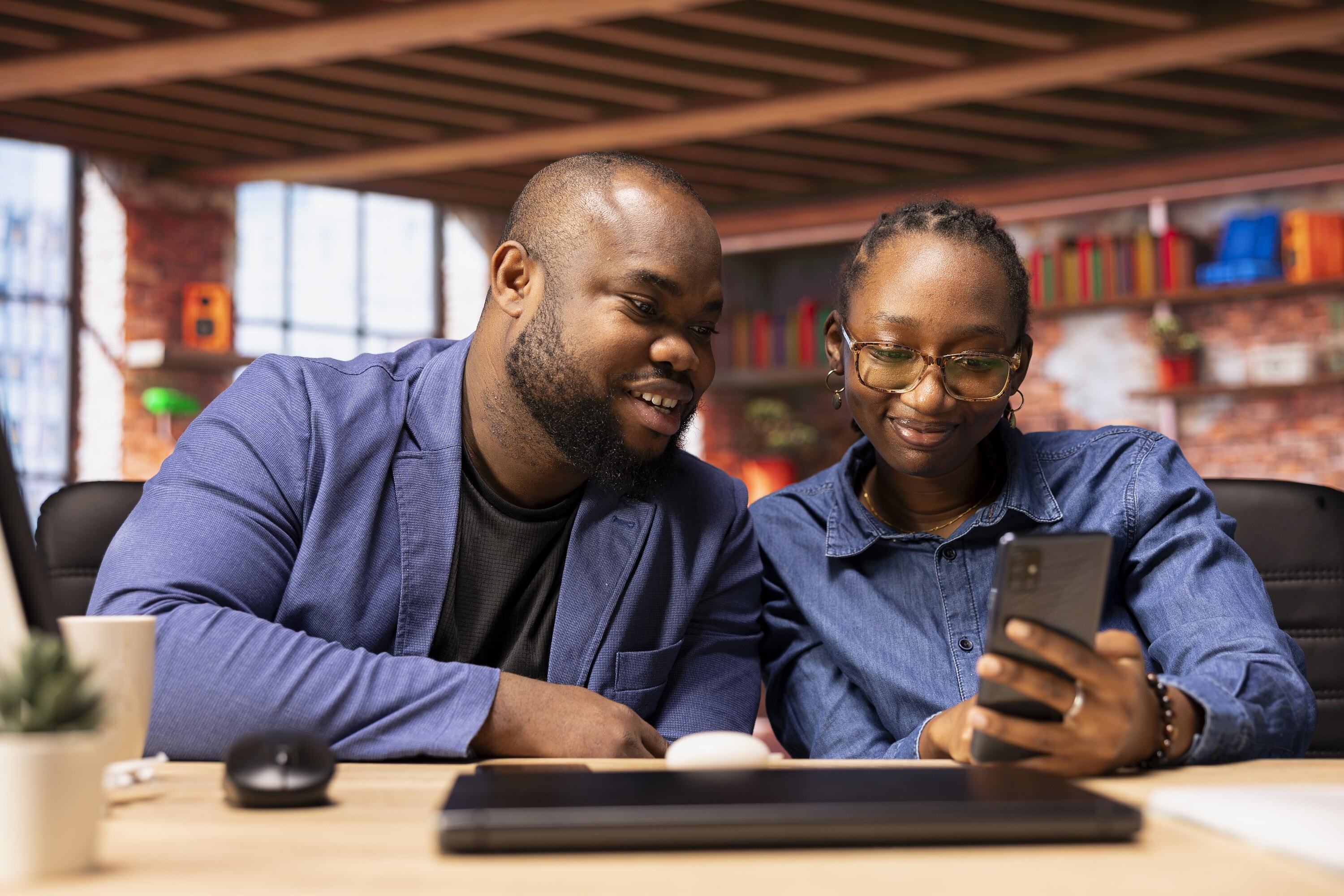 Two colleagues reading a message together at their desk